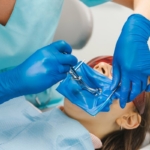Koferdam - dentystka przeprowadzająca leczenie u pacjentki z koferdamem