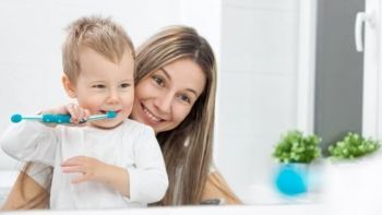 Jak dbać o zęby dziecka - mama ucząca synka myć zęby