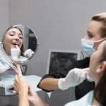 Wybielanie martwego zęba - dentystka i pacjentka oglądająca swoje zęby w lusterku