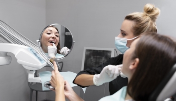Wybielanie martwego zęba - dentystka i pacjentka oglądająca swoje zęby w lusterku