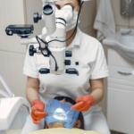 Endodoncja - dentystka przeprowadzające leczenie endodontyczne pod mikroskopem