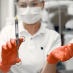 Rodzaje znieczuleń stomatologicznych - dentystka w gabinecie trzymająca strzykawkę ze znieczuleniem