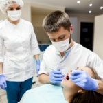 Szynowanie zębów - dentysta badający jamę ustną pacjentki