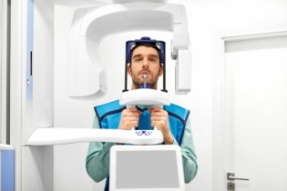 Pantomogram zębów - mężczyzna w trakcie badania pantomograficznego zębów