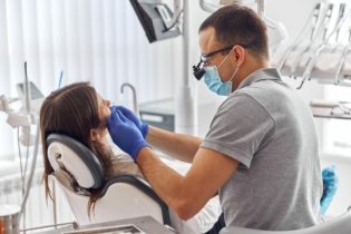 Martwy ząb - dentysta podczas leczenia pacjentki