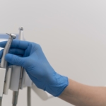 orthodontist with latex glove handling dental equipment