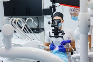 Kiedy leczenie kanałowe - dentysta wykonujący leczenie kanałowe pod mikroskopem
