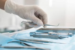 Kiretaż zamknięty - dentysta biorący z tacy kiret