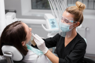 Cofanie się dziąseł - dentystka badająca jamę ustną pacjentki