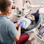Wkład koronowo-korzeniowy - dentysta leczący pacjentkę pod mikroskopem
